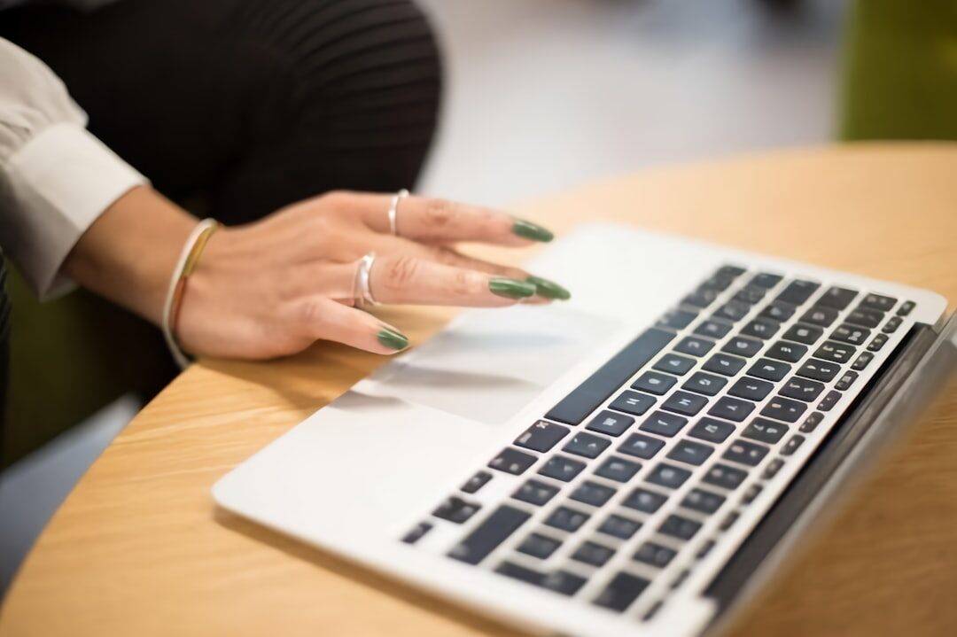 Hands typing on a laptop during a business discussion